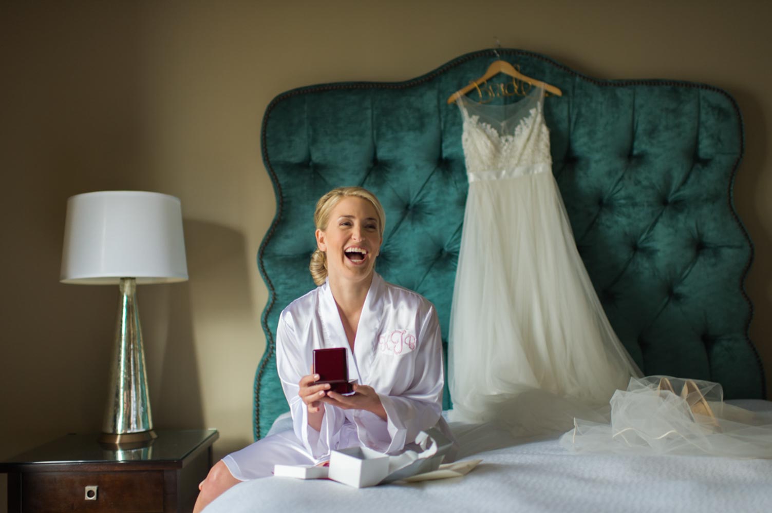 bride laughing after getting a gift from groom