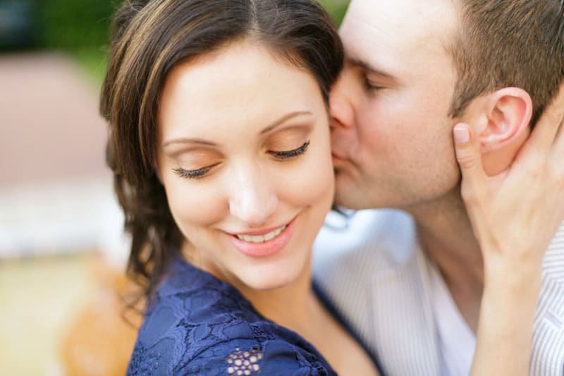 man kissing woman's cheek
