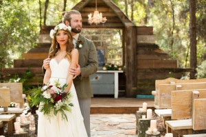 bride looking at camera with groom standing behind her