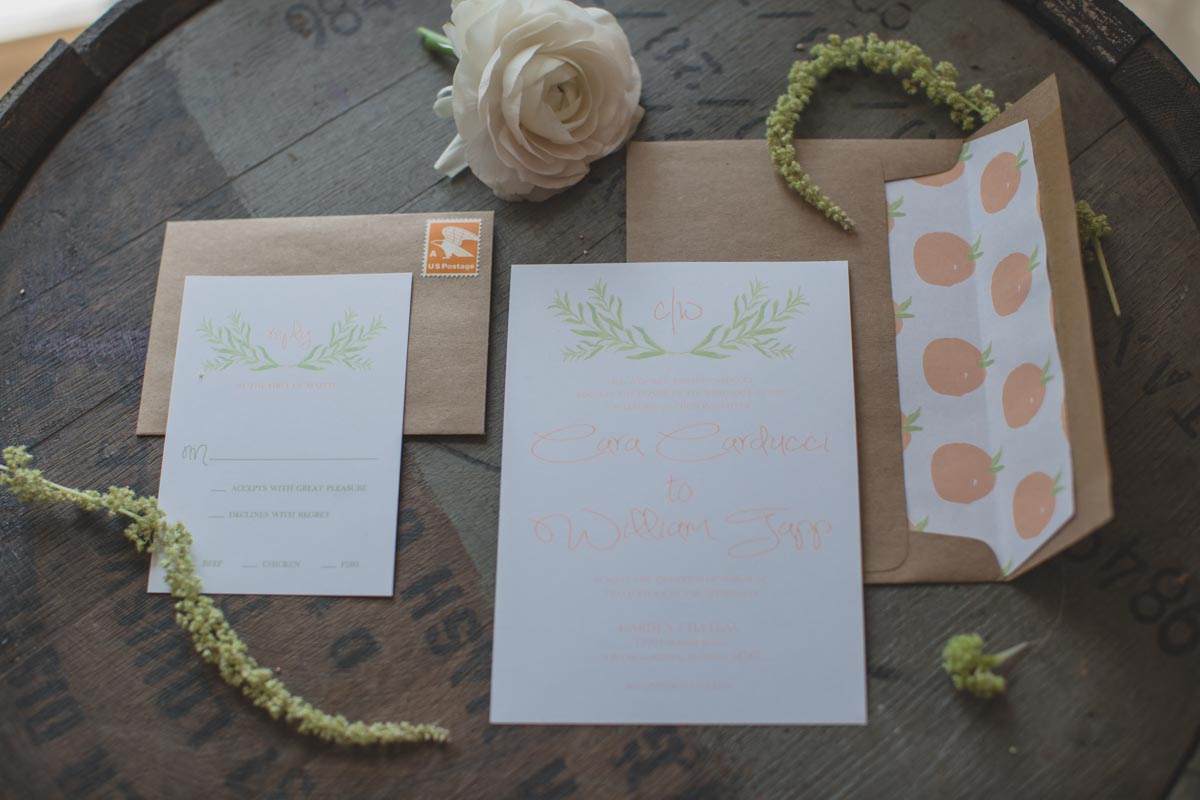orange inspired wedding invitation suite on wine barrel