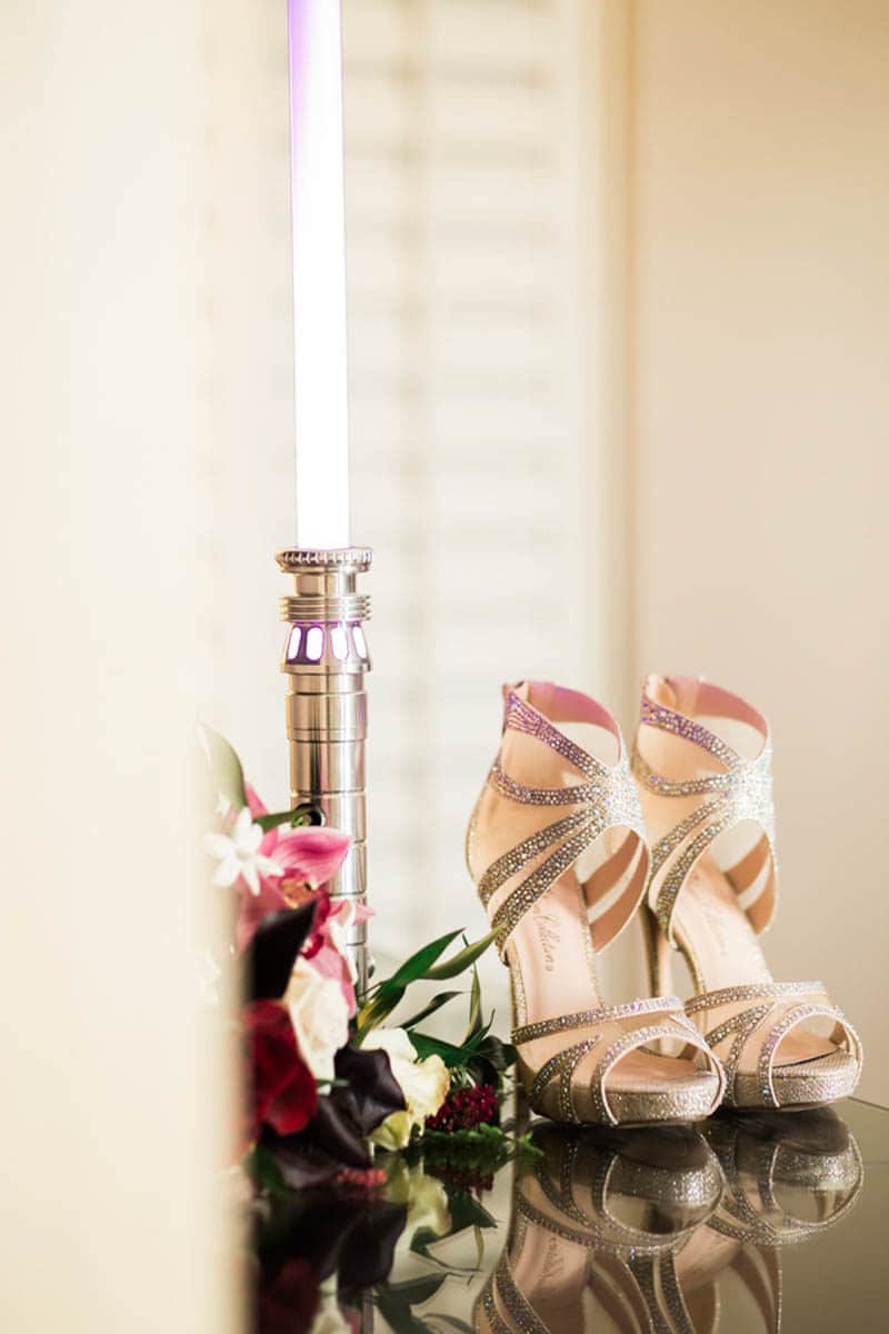 gold bridal shoes next to lightsaber