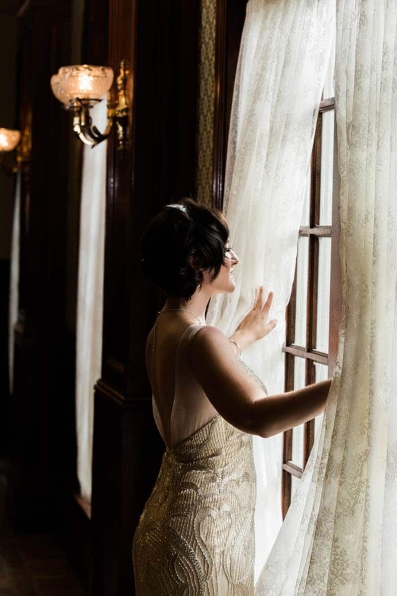 bride looking out window in bridal gown