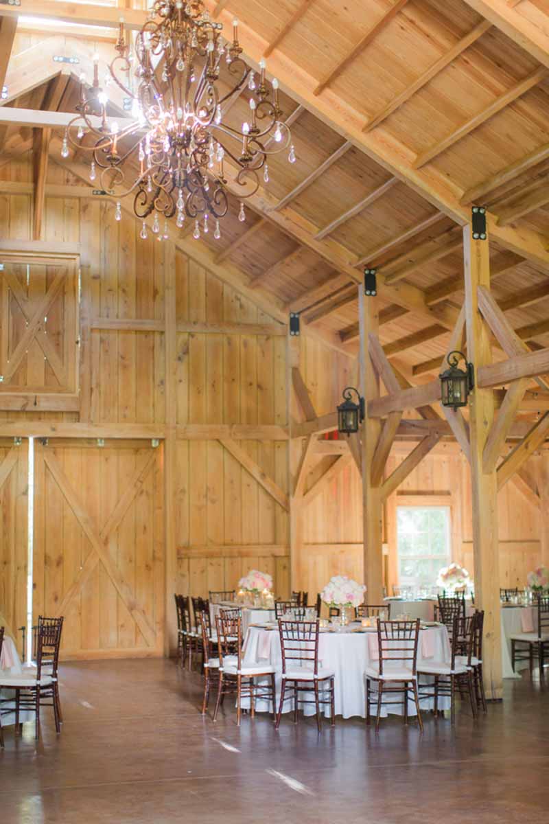 barn wedding reception with large chandelier