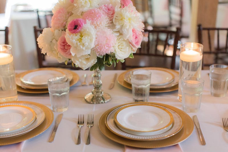 gold chargers with gold rimmed china on wedding reception tables