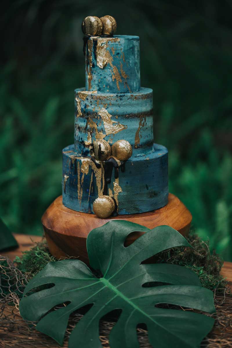 teal colored wedding cake with gold foiled macrons