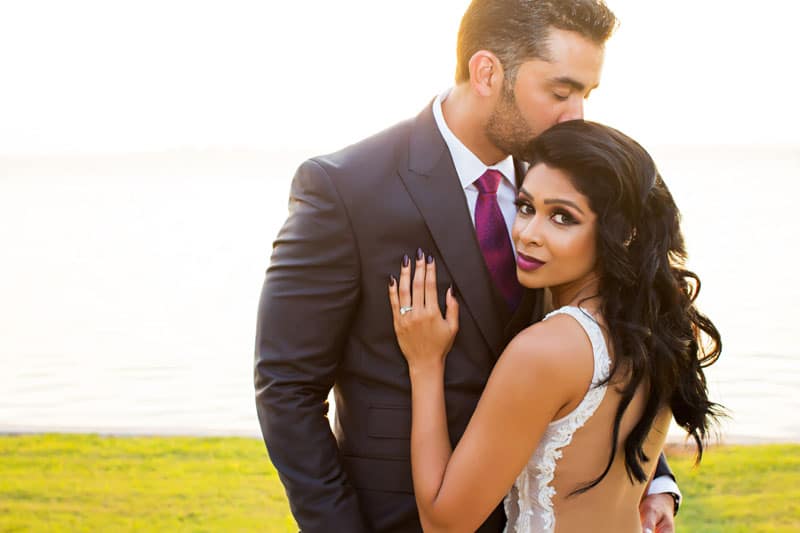 bride holding groom looking over shoulder