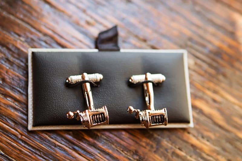 fishing reel cuff links on wood table