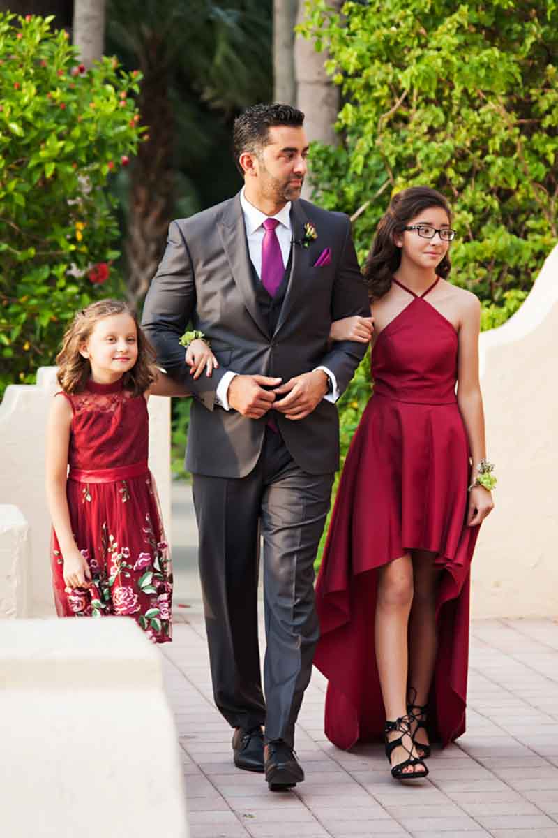 groom walking with junior bridesmaids