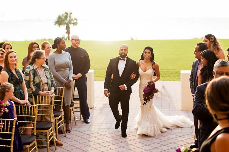 bride walking up the aisle holding bouquet