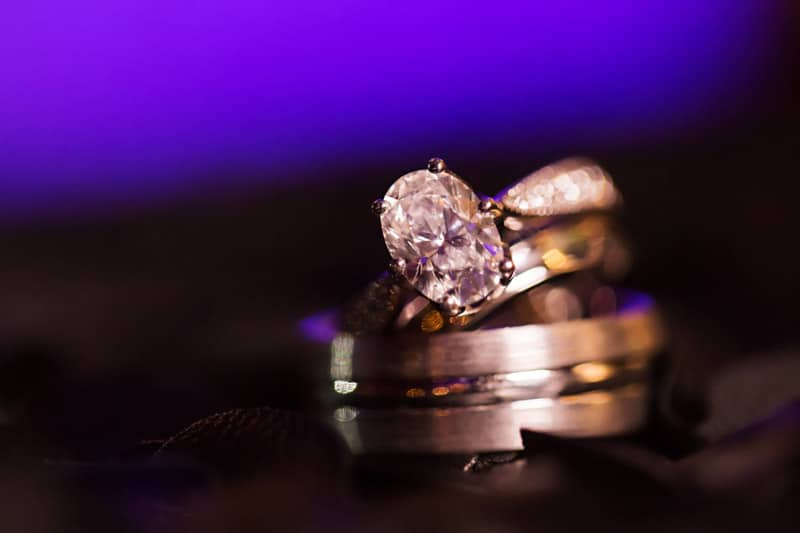 oval diamond engagement ring on top of men's band