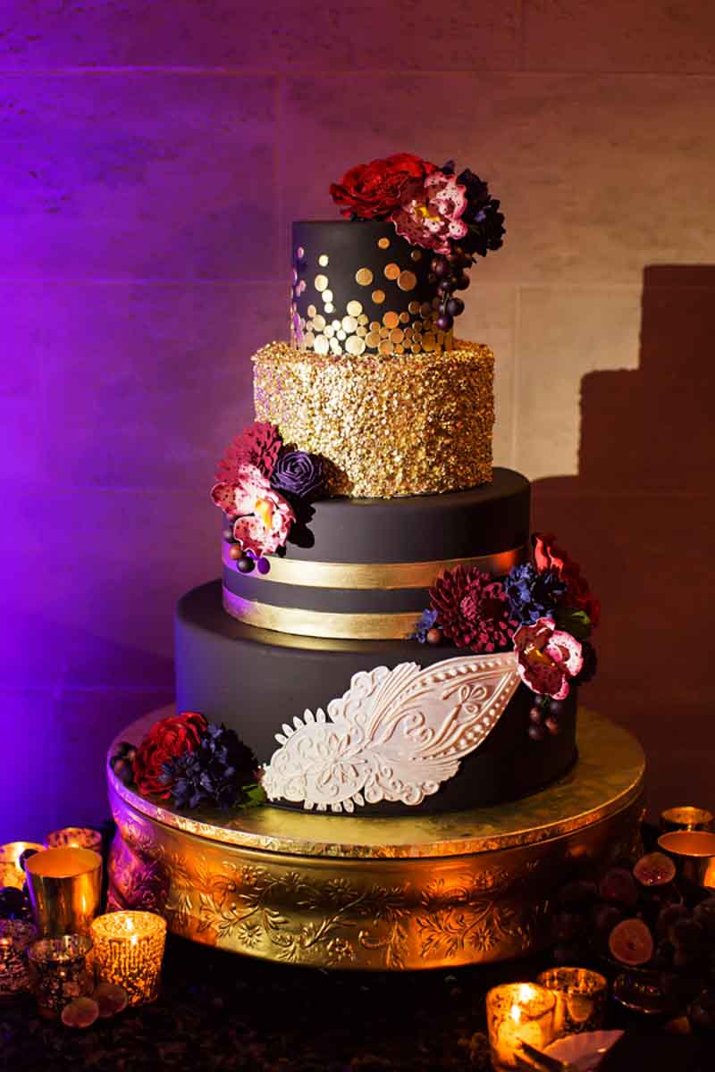 black and gold wedding cake on gold cake stand
