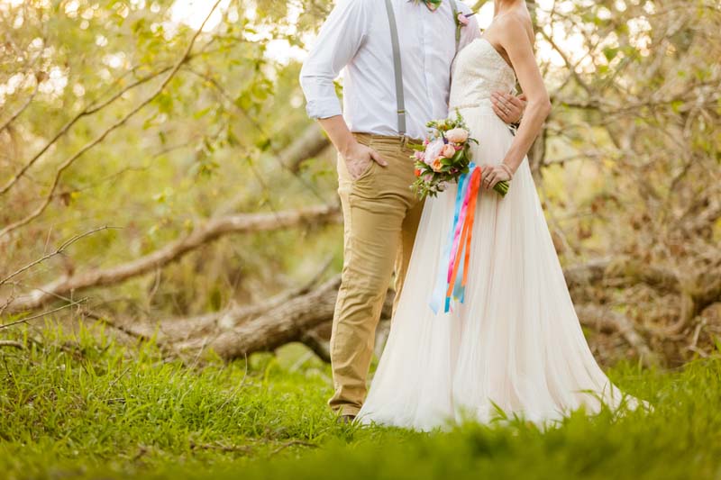 bride holding bouquet hugging groom