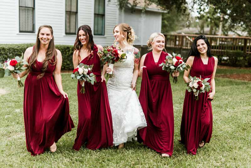 bridesmaids in burgundy dresses holding bouquets