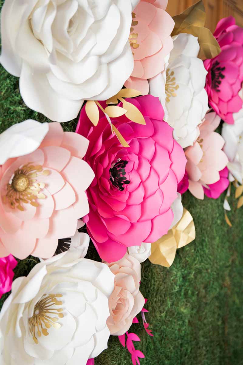 pink and blush paper flowers on hedge wall