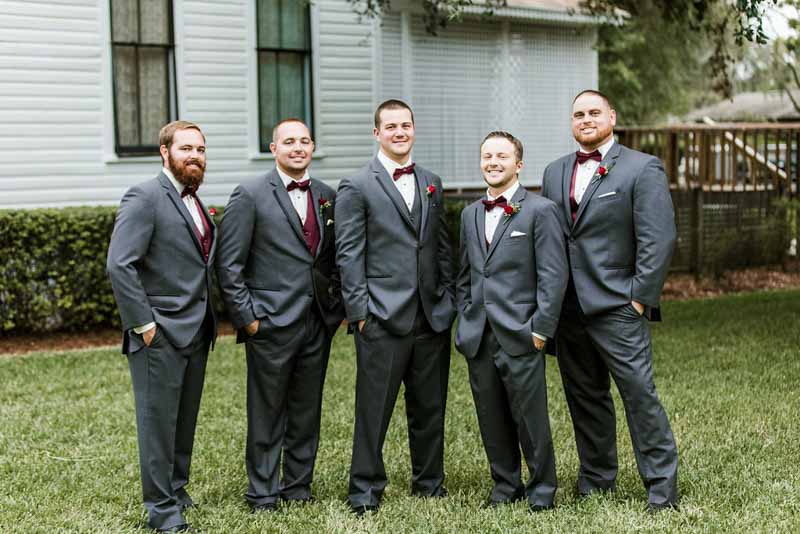 groom and groomsmen in grey suits with burgundy vests