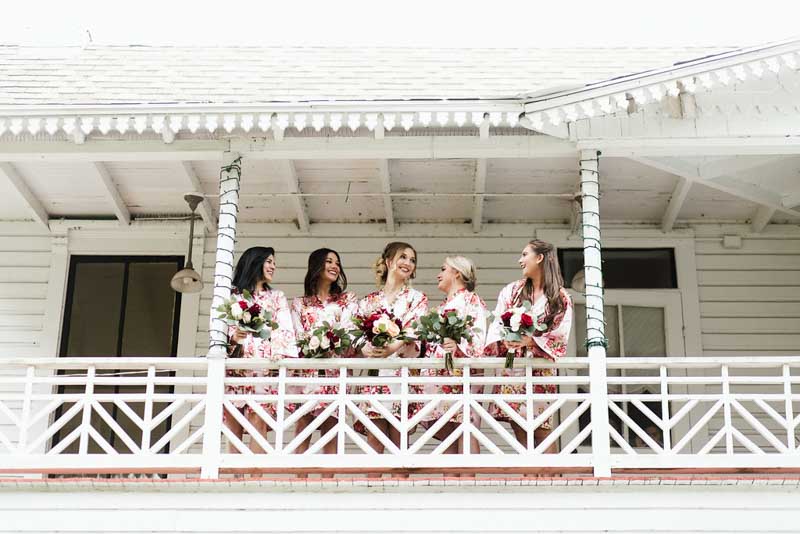 bride and bridesmaids in floral robes on balcony