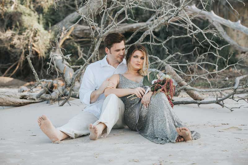 bride and groom sitting in sand for mermaid elopement inspiration shoot