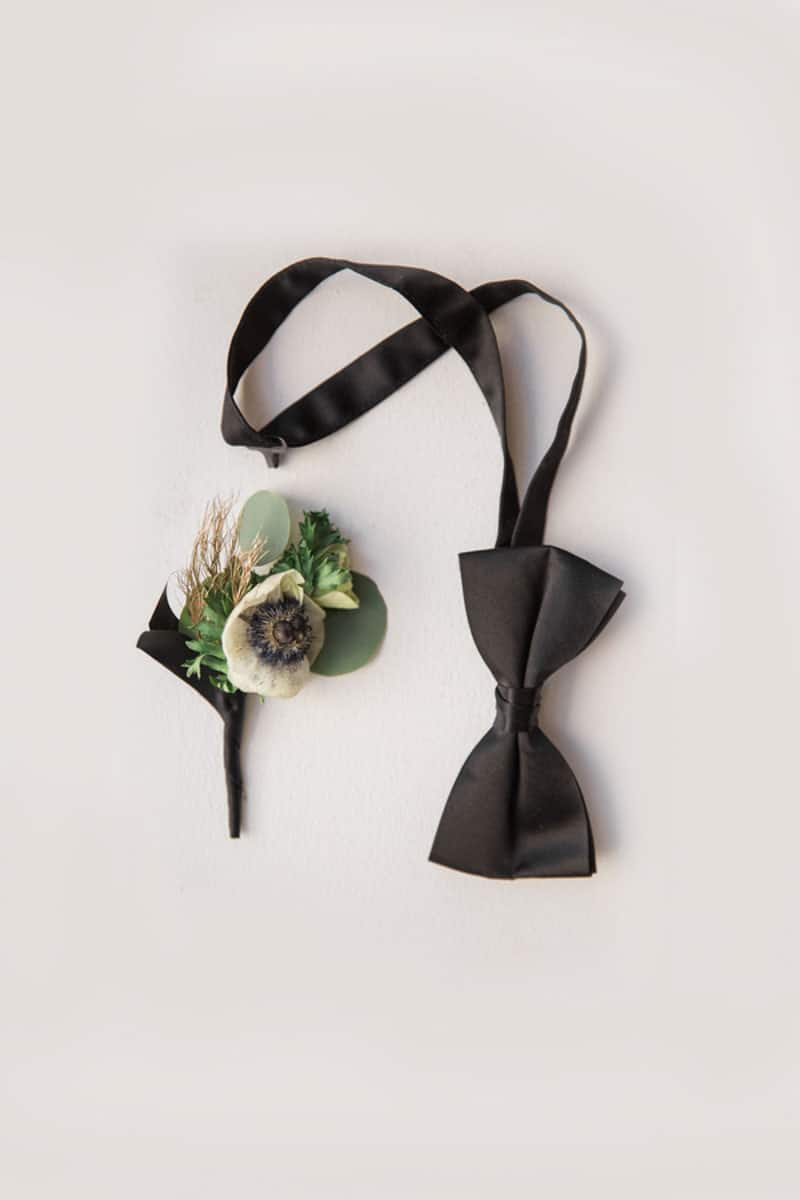 black bowtie next to boutonniere 