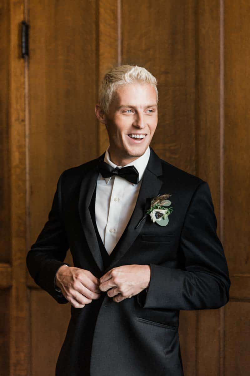 groom buttoning black tux