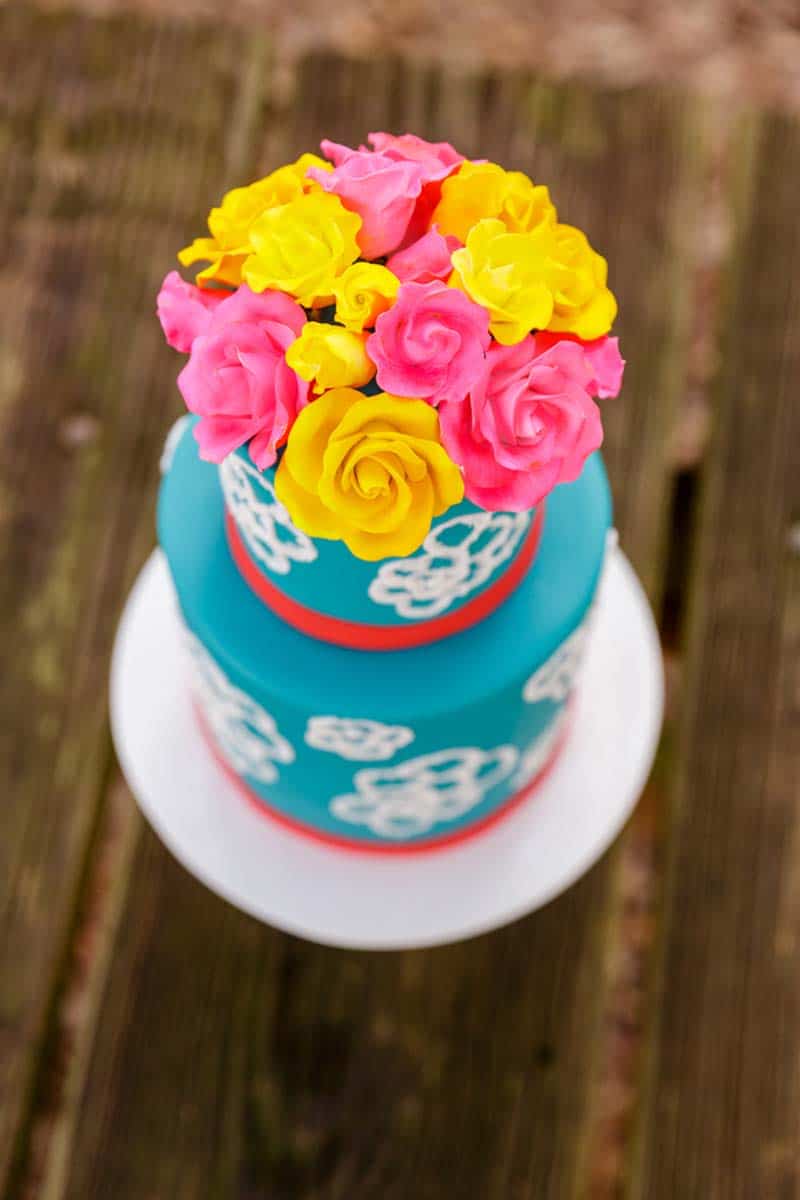 yellow and pink sugar flowers on blue cake