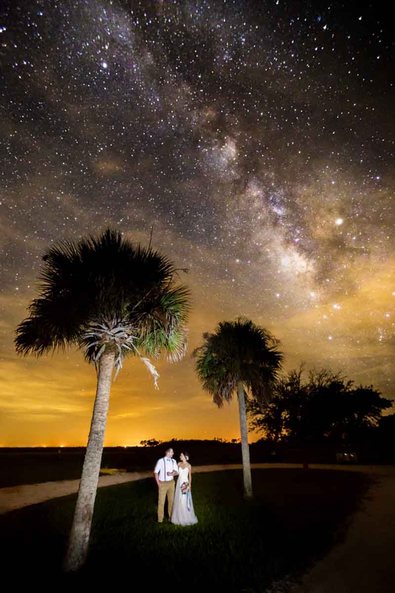 couple standing under milky way
