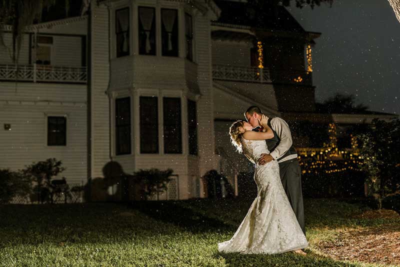 bride and groom kissing at night in front of the Mote-Morris House