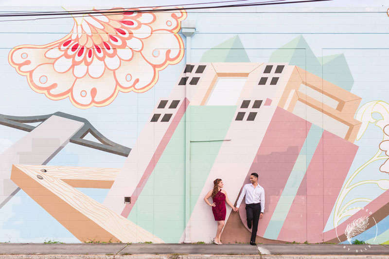 engaged couple leaning on wall mural in Mill 50 Orlando
