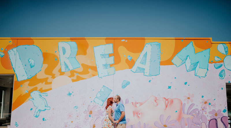Couple kissing in front of Children's Dream Fund Mural