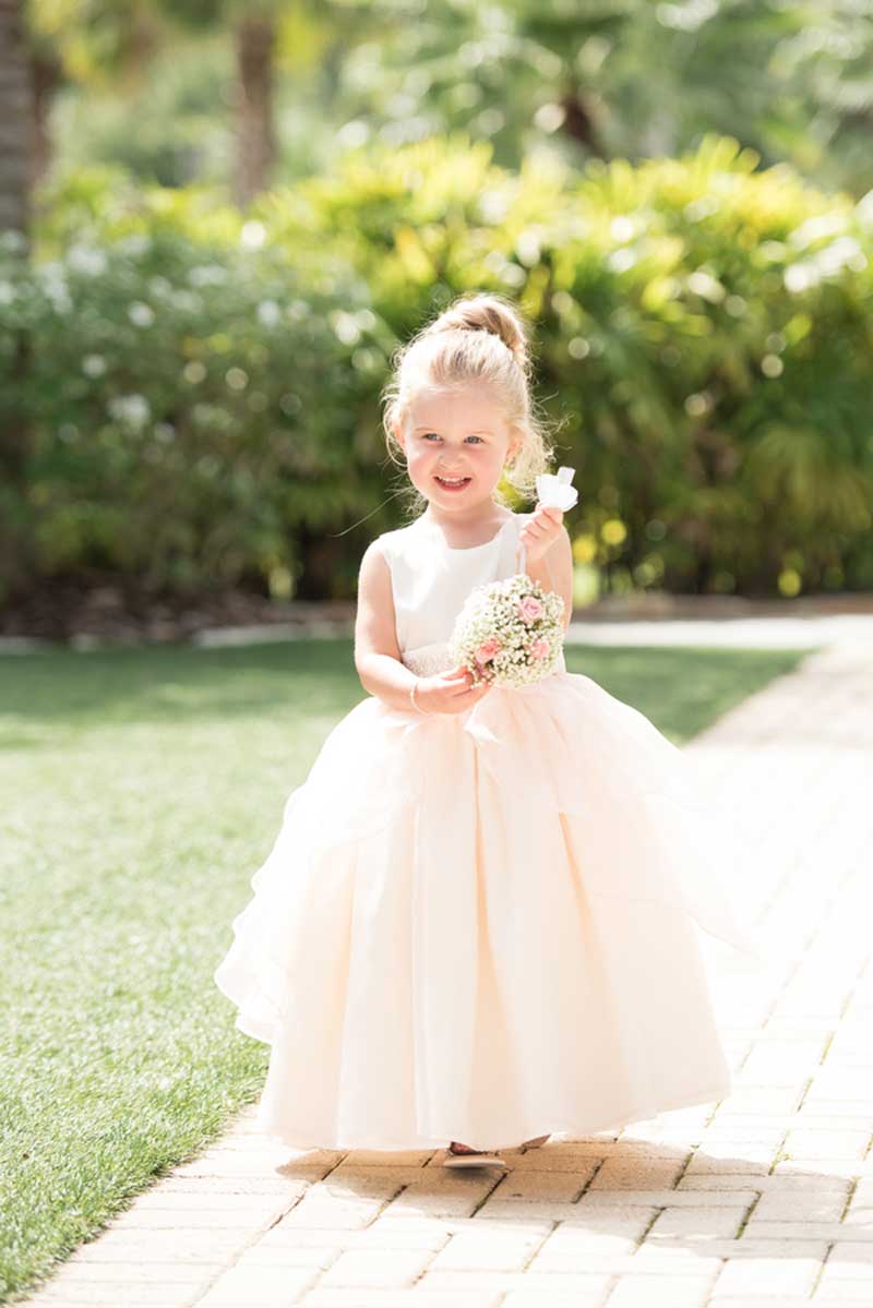 flower girl walking up the aisle in blush dress