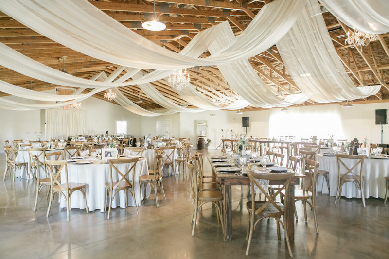Wedding barn reception space at Up the Creek Farms with drapery from rafters