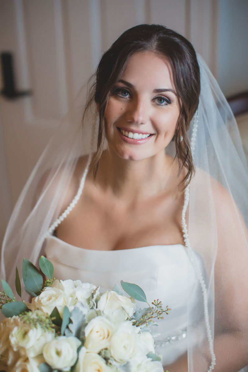 Bride wearing veil and holding white bouquet