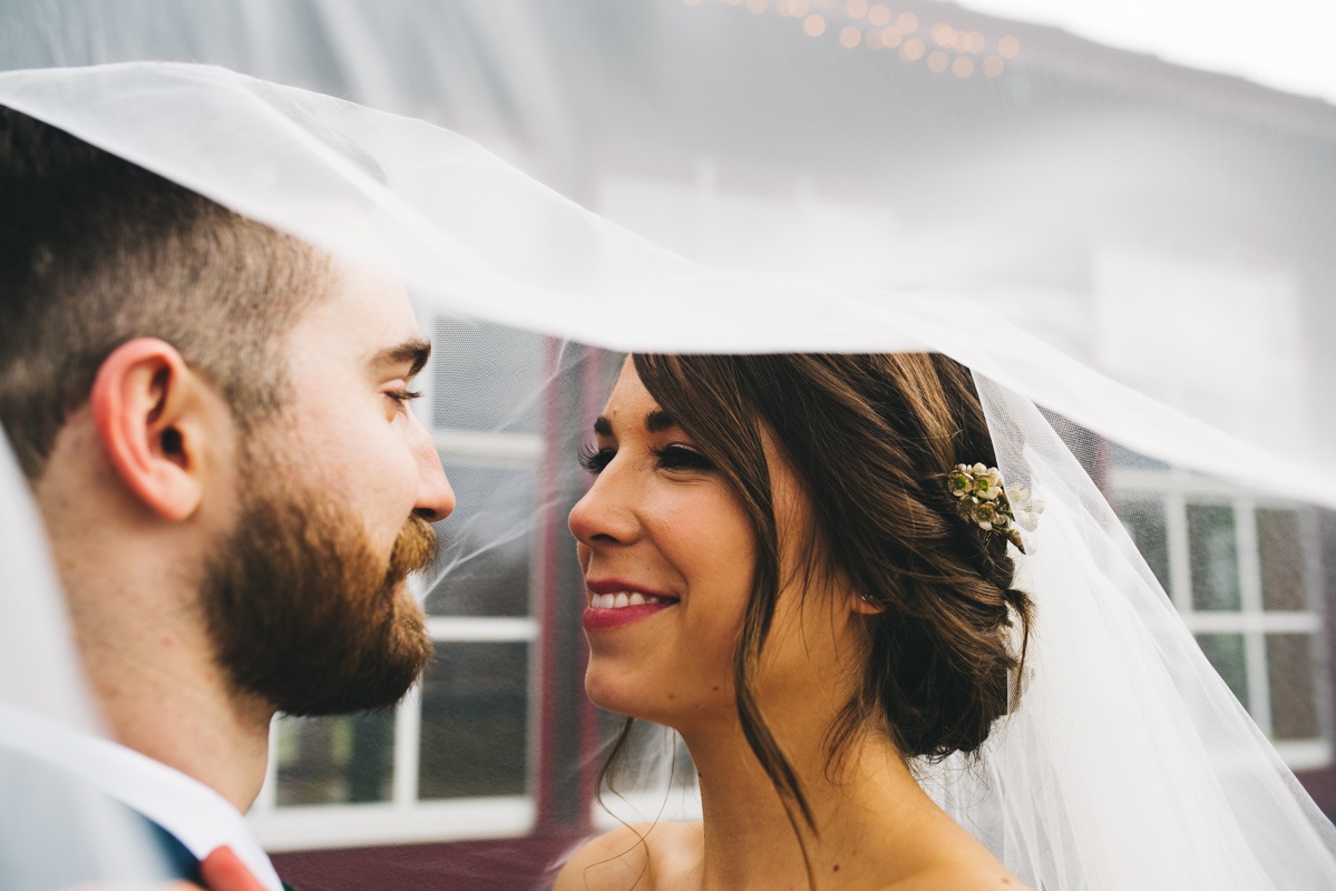 bride smiling at groom under wedding veil 