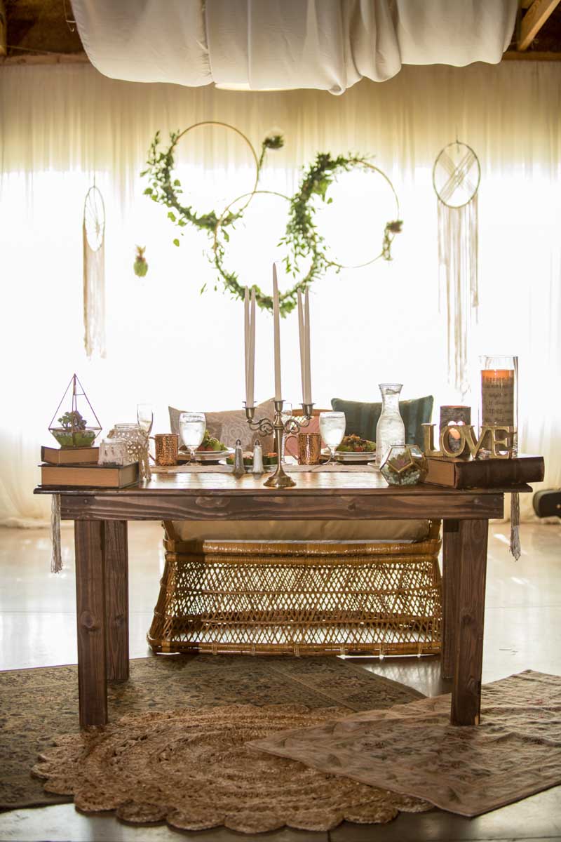 sweetheart table with wicker chair for wedding reception