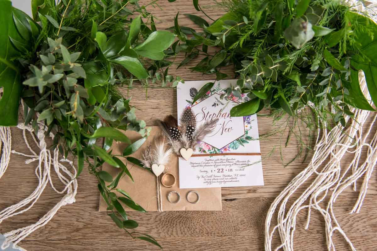 boho wedding invitations with feather boutonniere on top