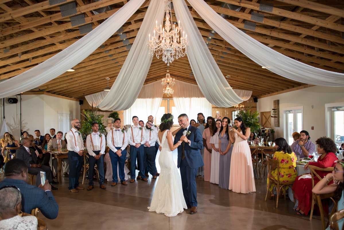 bride and groom dancing under crystal chandelier at wedding reception