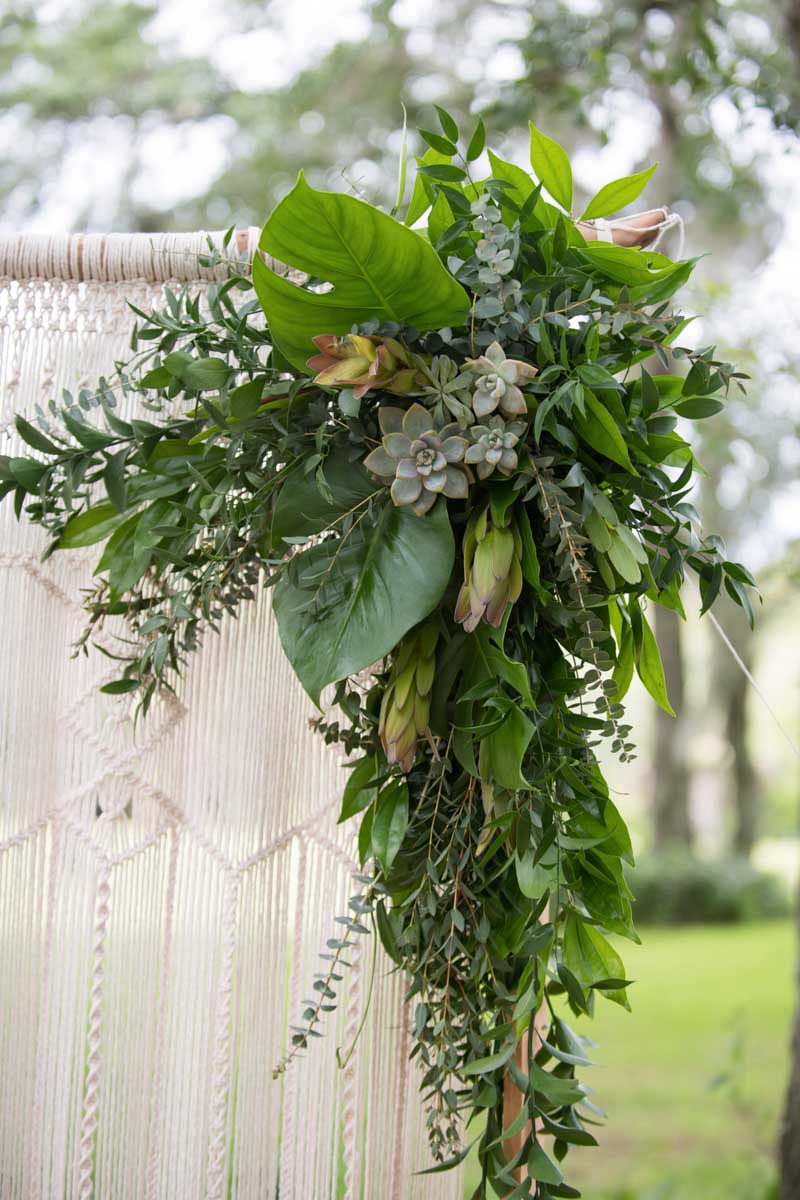 succulents and greenery on wedding macrame arch for wedding ceremony