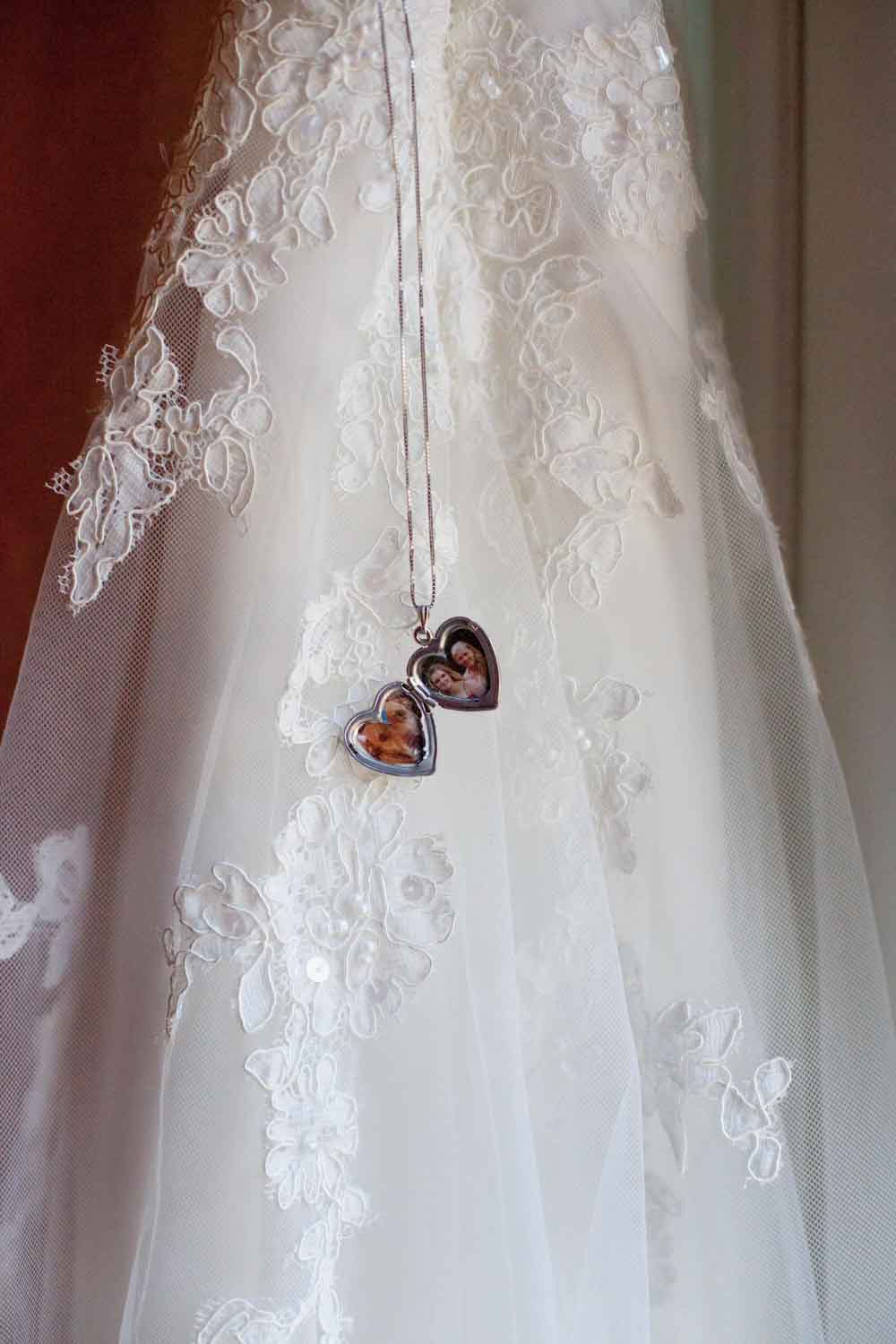 heart locket with photos inside next to wedding dress