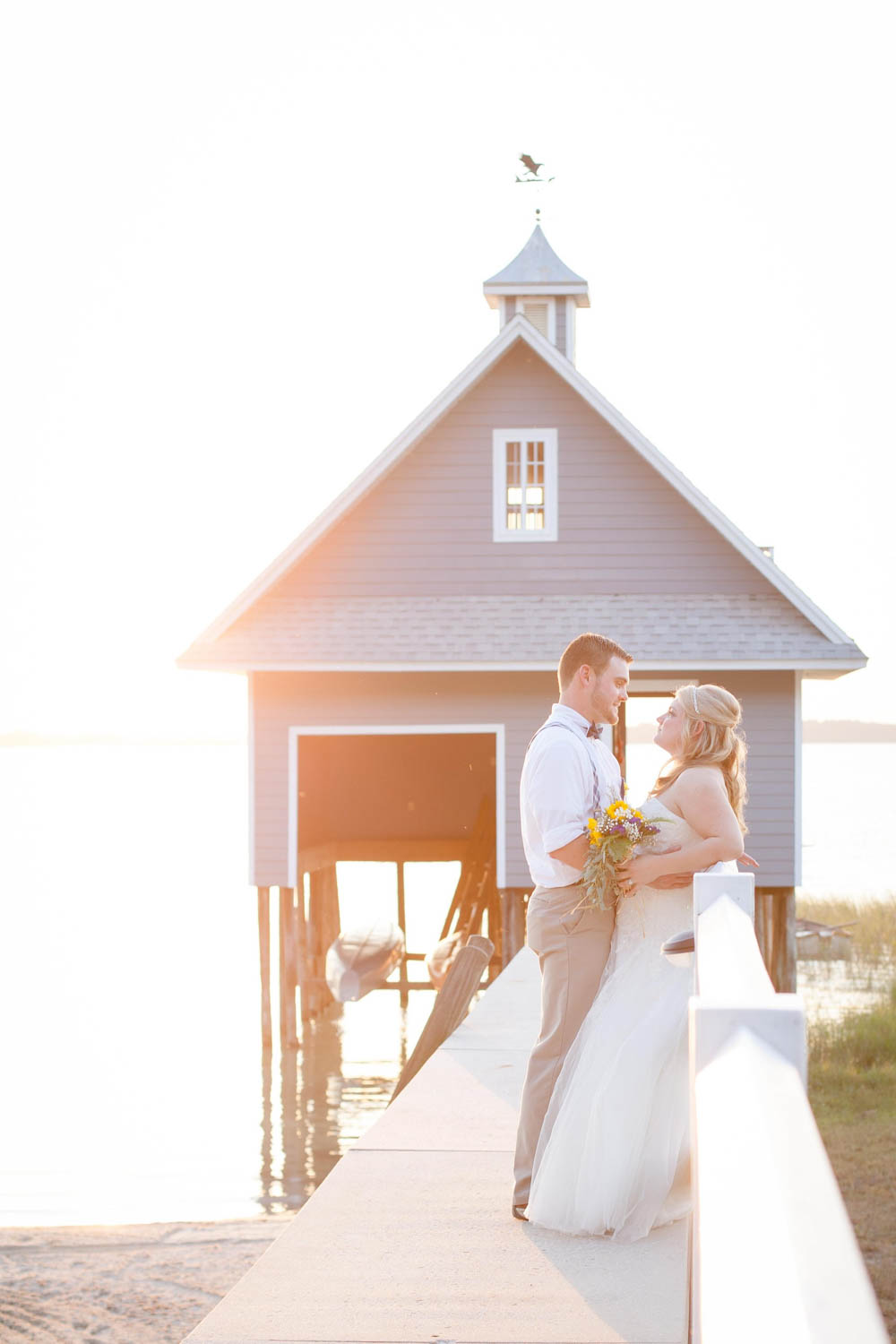 bride and groom on dock for sunset photos