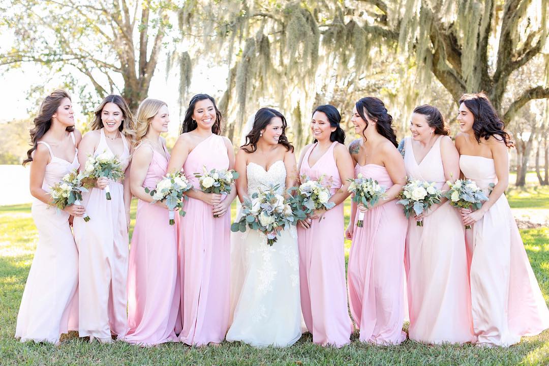 bride with her bridesmaids in pink dresses holding bouquets