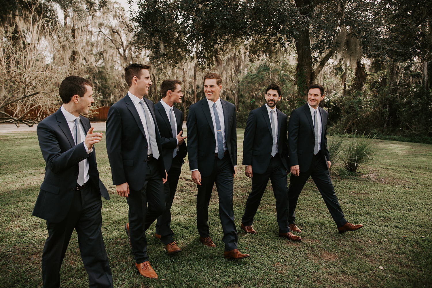 groom laughing with groomsmen outside