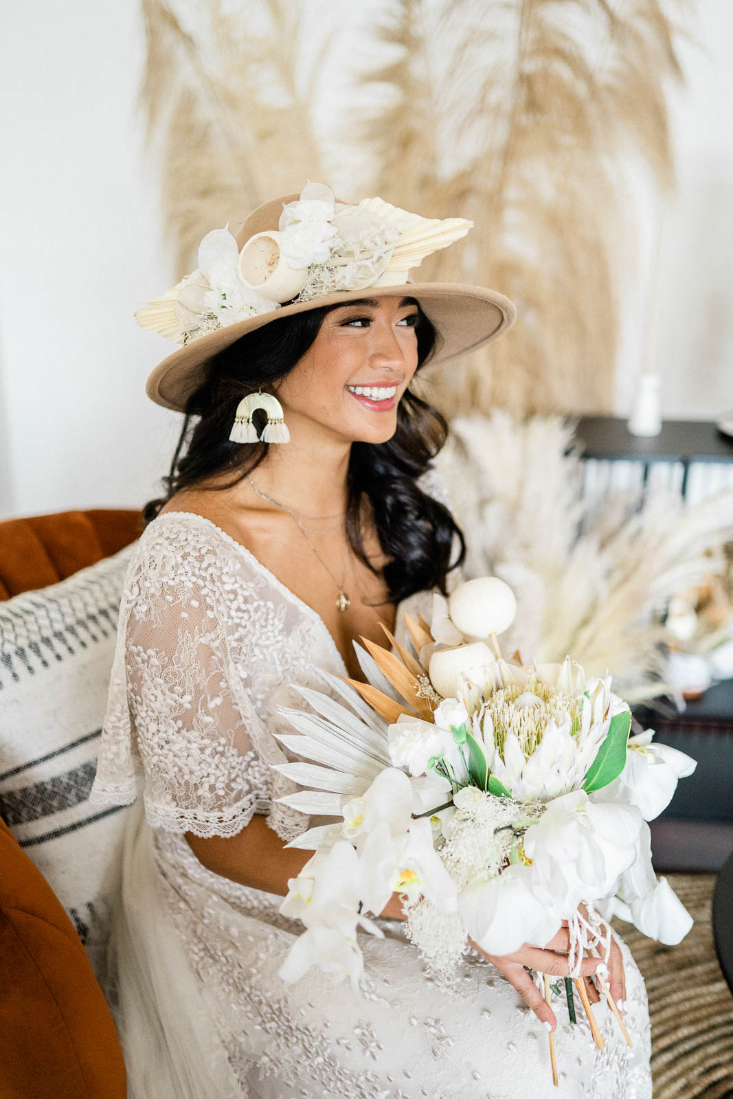 bride holding bouquet and wearing a hat with dried floral 