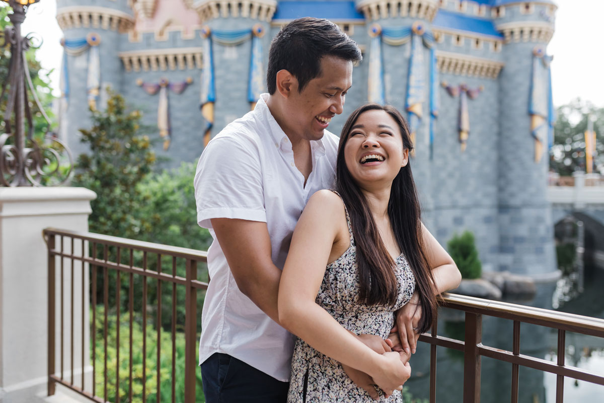 couple laughing in front of Cinderella's Castle at Magic Kingdom in Walt Disney World